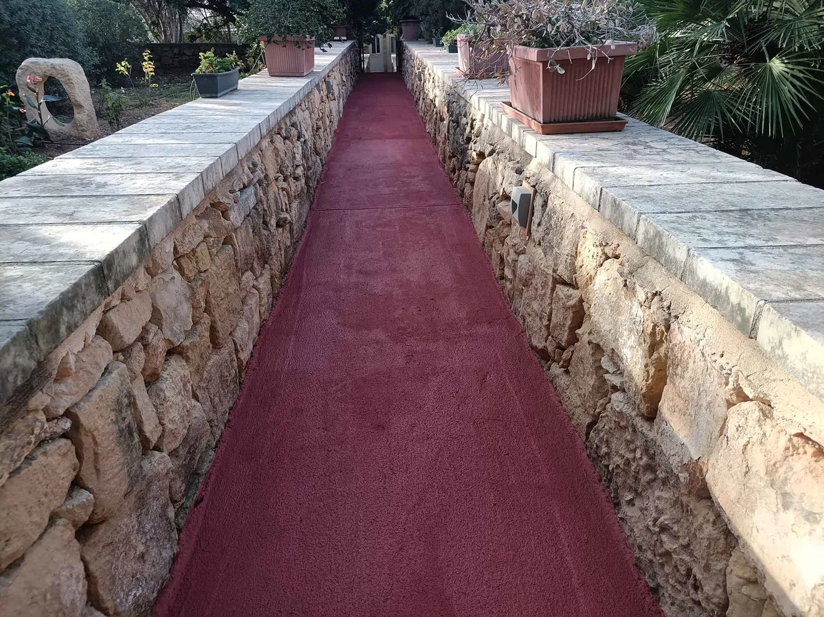 Coated outdoor path between rubble walls