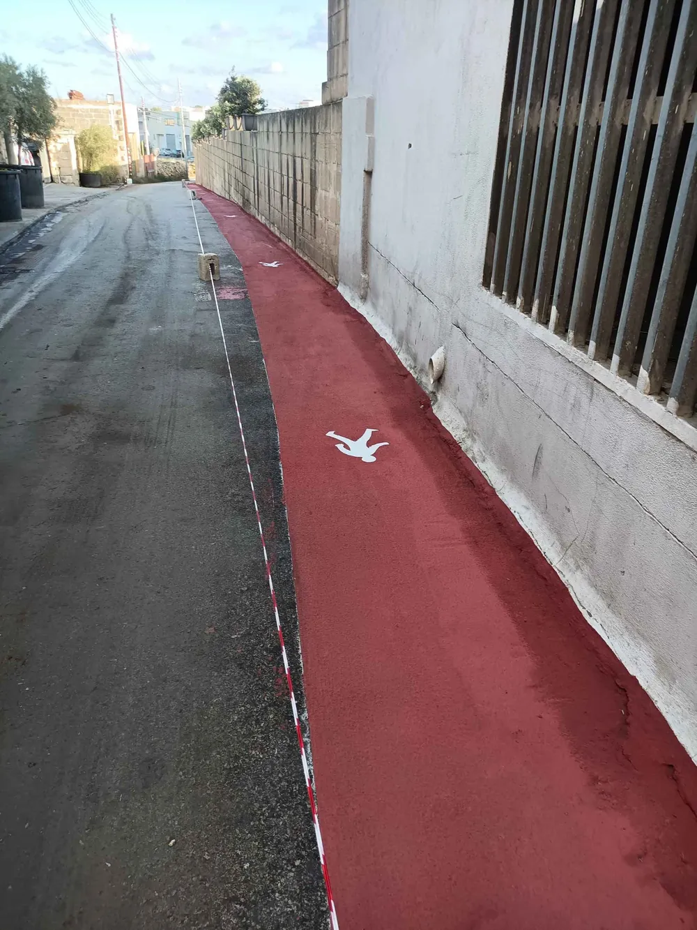 Red coated pedestrian walkway with markings