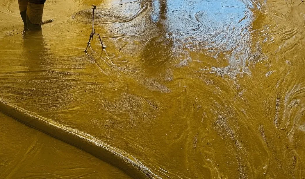 Liquid self-levelling screed being poured on a Malta floor